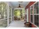 Screened patio with wooden chairs and table, ceiling fans, and a view of the lush backyard at 2941 Murraywood Rd, Johns Island, SC 29455