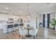 Open concept kitchen with seating at the island flowing into a dining area with modern lighting at 306 Lucca Dr, Summerville, SC 29486