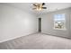 This bedroom features neutral walls, plush carpet, a ceiling fan, and a window providing natural light at 330 Bountiful Dr, Moncks Corner, SC 29461