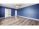 Bright bedroom featuring blue walls, wood-look floors, and an open doorway at 330 Bountiful Dr, Moncks Corner, SC 29461