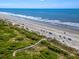 Scenic aerial view of the beach with a boardwalk surrounded by lush greenery at 3577 Shipwatch Rd, Kiawah Island, SC 29455