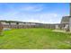 Wide shot of the large, green backyard surrounded by a wood fence and trees at 490 Pender Woods Dr, Summerville, SC 29486