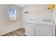 Bright laundry room features wooden floor, open shelving, and modern white washer and dryer at 490 Pender Woods Dr, Summerville, SC 29486