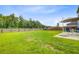 Spacious, grassy backyard with an outdoor dining set on a concrete patio and a wooden fence at 493 Spanish Wells Rd, Summerville, SC 29486