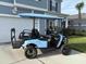 Stylish blue golf cart parked outside a home with well-manicured landscaping and an American flag at 493 Spanish Wells Rd, Summerville, SC 29486