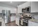 Close-up of a modern kitchen with stainless steel appliances and white cabinetry at 493 Spanish Wells Rd, Summerville, SC 29486