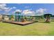 Community playground with swings, slides and a merry-go-round with a fenced area and neighborhood views at 493 Spanish Wells Rd, Summerville, SC 29486