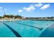 Long community pool with lap lines, lounge chairs and clubhouse with landscaping in the background at 493 Spanish Wells Rd, Summerville, SC 29486