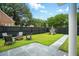 Backyard with a cozy firepit area, seating, a lush lawn, and a charming playhouse, perfect for outdoor activities at 51 Stocker Dr, Charleston, SC 29407