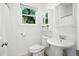 Bathroom with a pedestal sink, white fixtures, and a bright window at 51 Stocker Dr, Charleston, SC 29407