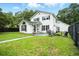 Exterior view of a white two-story house with a black fence, green lawn, and outdoor seating area at 51 Stocker Dr, Charleston, SC 29407