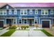 Charming blue townhome featuring stone accents, dark garage door, and landscaped front yard at 5133 Park Creek Ave, North Charleston, SC 29418