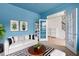 Inviting living room features a white sofa, striped rug, blue walls with white trim, and glass french doors at 5133 Park Creek Ave, North Charleston, SC 29418