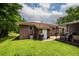 View of home's backyard showing well-kept lawn, brick exterior, and covered outdoor area at 5209 Sterrett St, North Charleston, SC 29405