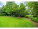 Lush backyard featuring a manicured lawn, black fence, and mature trees for privacy at 544 Two Mile Run, Johns Island, SC 29455