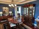 Elegant dining room featuring a wooden table, ornate chandelier, and built-in china cabinet for sophisticated dining at 544 Two Mile Run, Johns Island, SC 29455