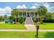 Inviting two-story home with a columned front porch, manicured landscaping, and a classic blue pickup truck at 544 Two Mile Run, Johns Island, SC 29455
