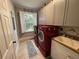 Modern laundry room with red washer and dryer, white cabinetry, and a window for natural light at 544 Two Mile Run, Johns Island, SC 29455