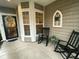 Cozy covered porch featuring rocking chairs, decorative wreaths, and charming accents at 556 Sea Foam St, Summerville, SC 29486
