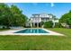 Exterior shot of the house and backyard featuring a sparkling pool and manicured green lawn at 591 Island Walk East, Mount Pleasant, SC 29464