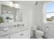 Well-lit bathroom featuring a stylish vanity, a marble countertop, and a toilet near the window at 591 Island Walk East, Mount Pleasant, SC 29464