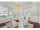 Bright dining room with hardwood floors, featuring stylish chandelier, wainscoting, and windows at 591 Island Walk East, Mount Pleasant, SC 29464