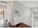 Hallway with hardwood floors, white wainscoting, stairs, and light-filled with a view from the window at 591 Island Walk East, Mount Pleasant, SC 29464