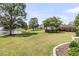 Expansive backyard featuring lush green lawn, landscaping, and tranquil pond with fountain view at 602 Eastern Isle Ave, Summerville, SC 29486