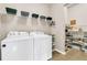 Bright laundry room with washer, dryer, and ample storage shelving at 602 Eastern Isle Ave, Summerville, SC 29486