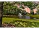Picturesque pond featuring a fountain, surrounded by lush greenery and mature trees under a sunset sky at 602 Eastern Isle Ave, Summerville, SC 29486