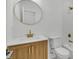 Modern bathroom features a wood cabinet with a white countertop, gold fixtures, and a round mirror at 6513 Highway 162, Hollywood, SC 29449