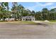 Exterior of home with driveway, green grass, trees, and blue front door at 6513 Highway 162, Hollywood, SC 29449