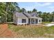 Exterior of the home with manicured lawn, lush trees, and a charming covered front porch at 6513 Highway 162, Hollywood, SC 29449