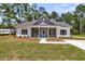 Charming single-story home featuring a covered porch, gray accents, and well-maintained landscaping at 6513 Highway 162, Hollywood, SC 29449