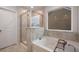 Relaxing bathroom with a soaking tub, separate shower, and neutral tile at 701 Squire Pope Rd, Summerville, SC 29486