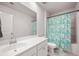 Bright bathroom with a white vanity, a large mirror, and a shower with a colorful paisley patterned curtain at 701 Squire Pope Rd, Summerville, SC 29486