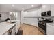 Spacious kitchen with modern appliances, white cabinets, hardwood floors, and a view of the staircase at 701 Squire Pope Rd, Summerville, SC 29486