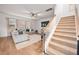 Bright living room next to carpeted staircase featuring a comfy sofa and TV at 701 Squire Pope Rd, Summerville, SC 29486