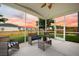 Inviting screened porch with comfortable wicker furniture and a view of the backyard at sunset at 701 Squire Pope Rd, Summerville, SC 29486