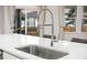 Close up of stainless sink with modern faucet, granite countertop, with windows and curtains in the background at 701 Squire Pope Rd, Summerville, SC 29486