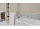 Bathroom featuring a bright white bathtub, marble backsplash and convenient shelving at 7021 Schooner St, Charleston, SC 29492