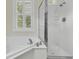 Bright bathroom featuring soaking tub and shower with glass enclosure at 7021 Schooner St, Charleston, SC 29492