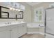 Bright bathroom featuring double vanity, soaking tub, and walk-in shower at 7021 Schooner St, Charleston, SC 29492