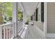 Inviting covered front porch features white railing, black shutters, and ample space for outdoor relaxation at 7021 Schooner St, Charleston, SC 29492
