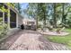 Backyard brick patio featuring an outdoor grill, fire pit with chairs and a covered porch area at 7021 Schooner St, Charleston, SC 29492