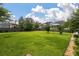 Expansive backyard featuring a large grassy area surrounded by a dark wooden fence and lush trees at 705 Quintan St, Summerville, SC 29486
