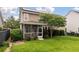 Beautiful backyard view featuring the screened in porch, green grass, and trees at 705 Quintan St, Summerville, SC 29486