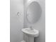 A sleek bathroom with a pedestal sink and an oval mirror at 705 Quintan St, Summerville, SC 29486