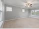 An empty bedroom with carpet and a ceiling fan showcases natural light through windows at 705 Quintan St, Summerville, SC 29486