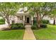 Charming home exterior with a welcoming front porch and lush landscaping with mature trees and shrubbery at 705 Quintan St, Summerville, SC 29486